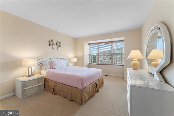 20900 Trinity Square Sterling, VA 20165 - Photo 25 of 38 a spacious bedroom with a bed a table and large window