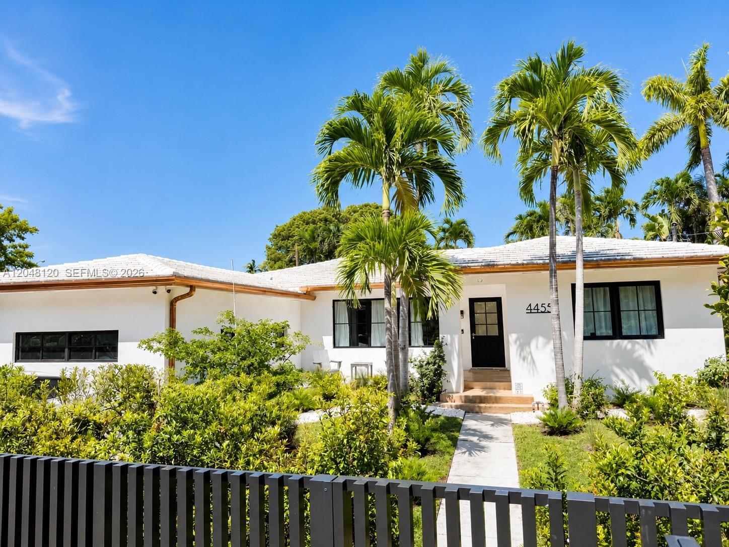 4455 North Bay Road Miami Beach, FL 33140 - Photo 1 of 14 a front view of a house with a yard