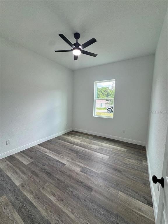 5394 Northwest 6th Place Ocala, FL 34482 - Photo 16 of 42 wooden floor in an empty room with a window