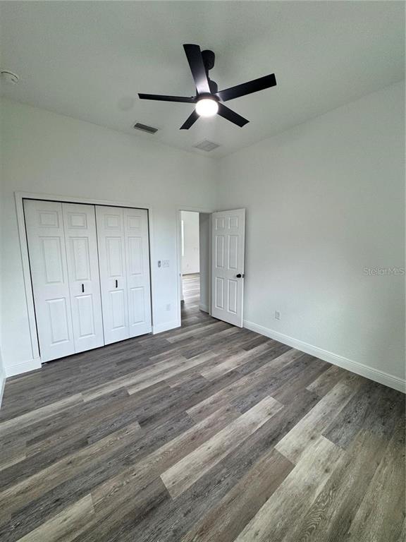 5394 Northwest 6th Place Ocala, FL 34482 - Photo 22 of 42 an empty room with wooden floor ceiling fan and windows