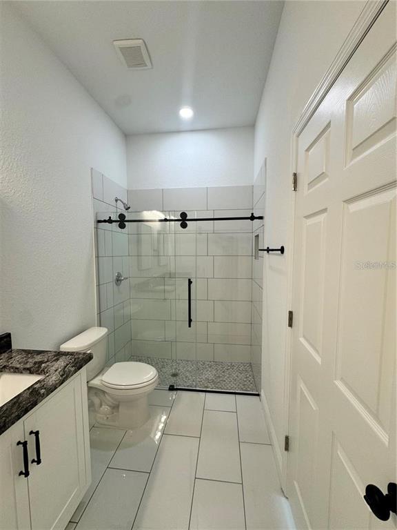 5394 Northwest 6th Place Ocala, FL 34482 - Photo 33 of 42 a bathroom with a granite countertop shower a toilet and sink