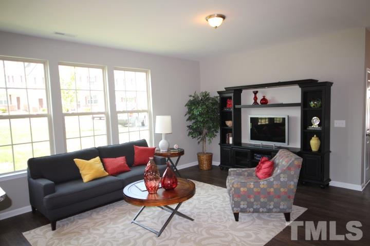 1019 Grand Ridge Drive Rolesville, NC 27571 - Photo 6 of 25 a living room with furniture a flat screen tv and a large window