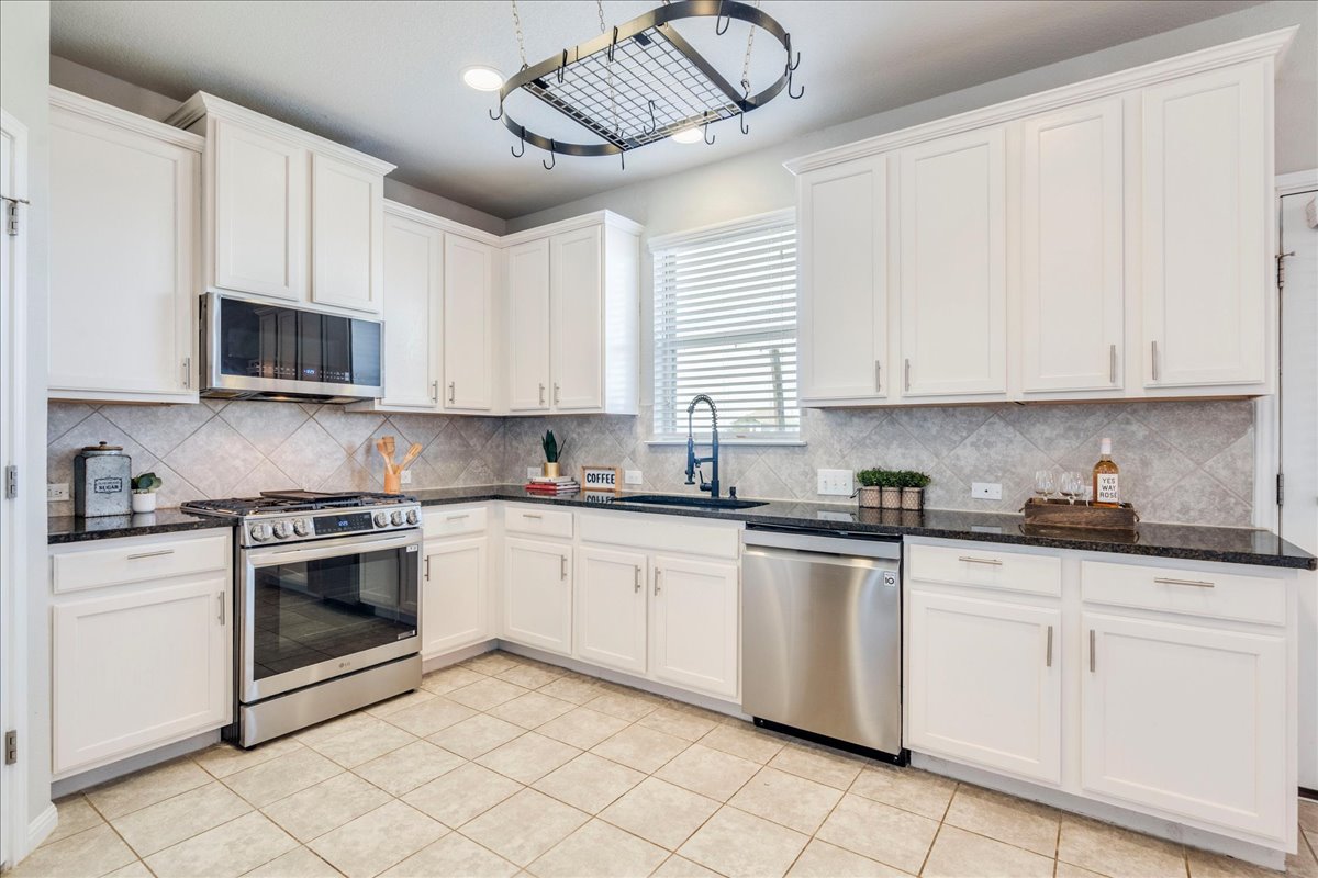 312 Triumph Road Buda, TX 78610 - Photo 16 of 37 Kitchen features upgraded stainless appliances, granite countertops, 42" white cabinetry and upgraded large farmhouse sink!