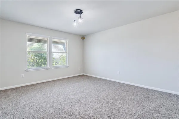 a bedroom with a bed a chandelier and a window