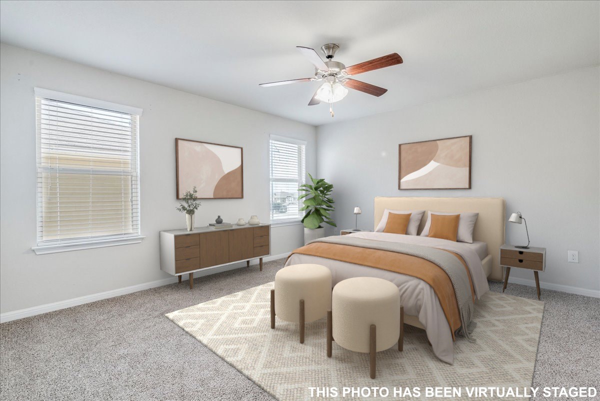 312 Triumph Road Buda, TX 78610 - Photo 22 of 37 Virtually staged. Primary bedroom features windows providing natural light, ceiling fan and accent wall.