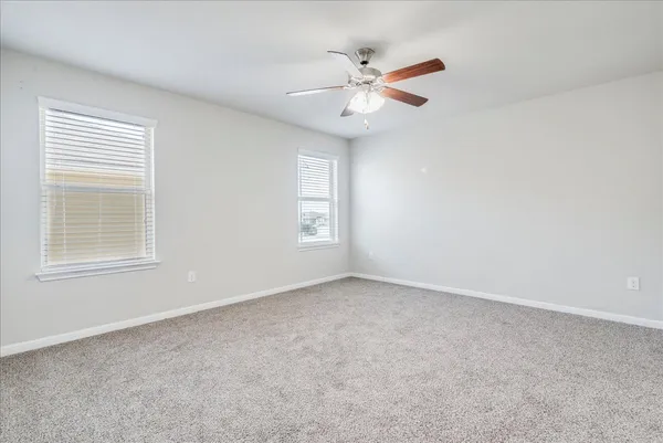 an empty room with fan and entrance