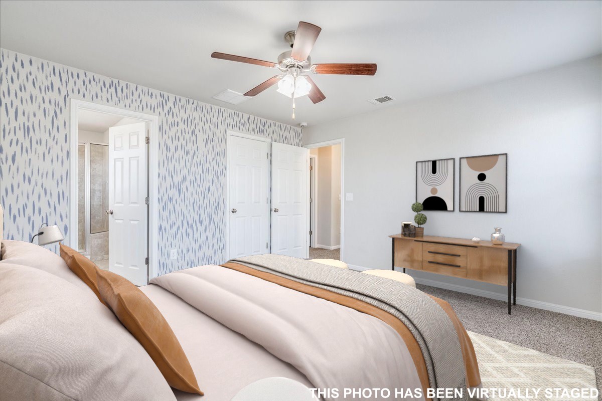 312 Triumph Road Buda, TX 78610 - Photo 24 of 37 Virtually staged. Primary bedroom features windows providing natural light, ceiling fan and accent wall.