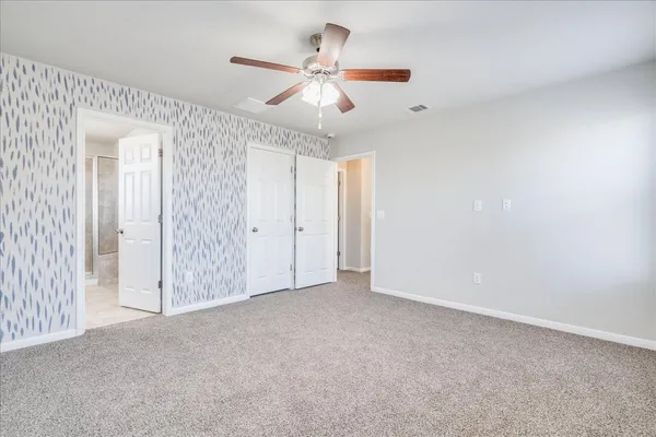 an empty room with a window and a fan