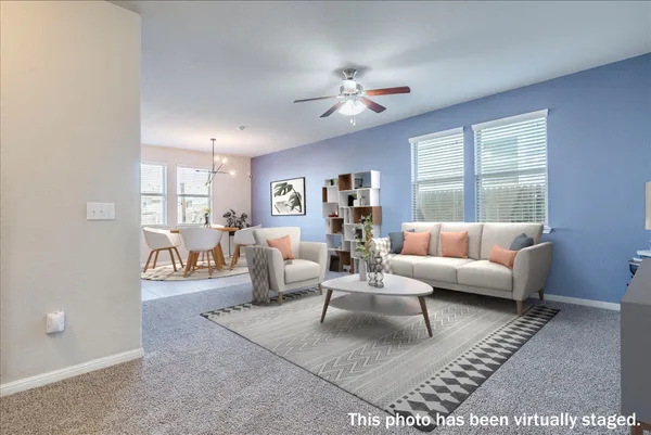 an empty room with windows and chandelier fan