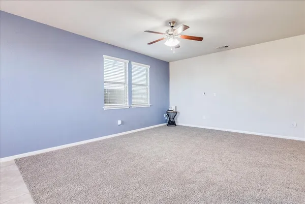 a view of an empty room with a window and a kitchen