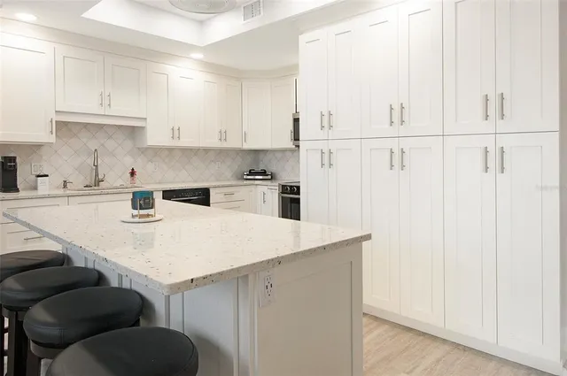 a kitchen with a sink cabinets and white appliances