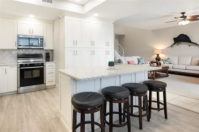 a kitchen with granite countertop a table chairs stove and cabinets