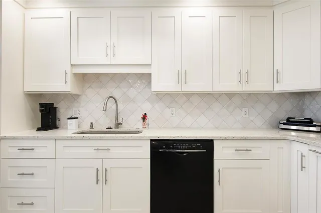 a kitchen with white cabinets and a sink