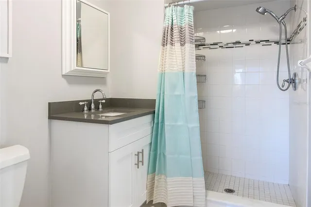 a bathroom with a sink shower and a mirror