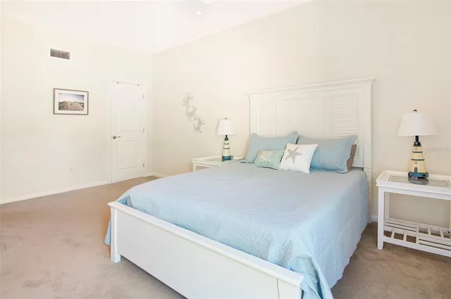 a bedroom with a bed and a flat tv screen on dresser