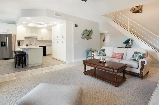 a living room with furniture and view of kitchen