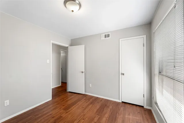 a view of an empty room with wooden floor