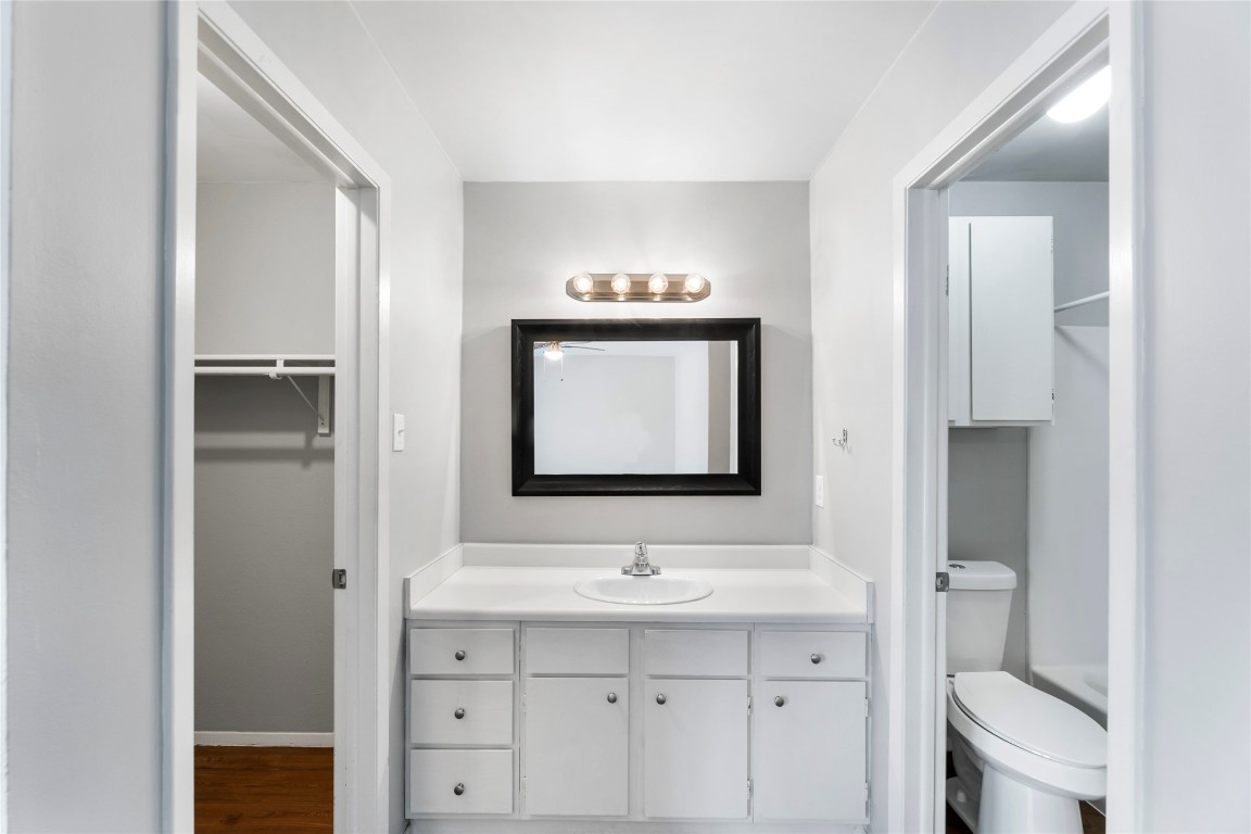 4304 Acropolis Court, Unit B Austin, TX 78759 - Photo 13 of 22 a bathroom with a sink a toilet and a large mirror