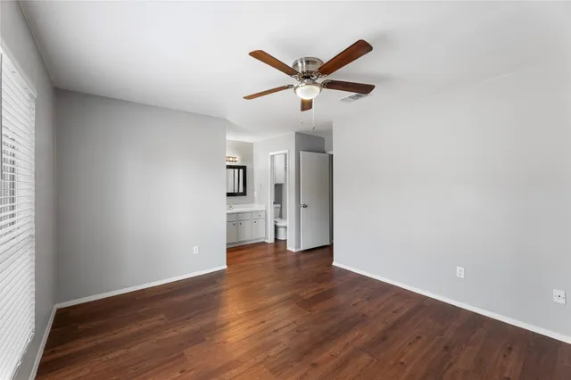 a view of a big room with wooden floor and windows