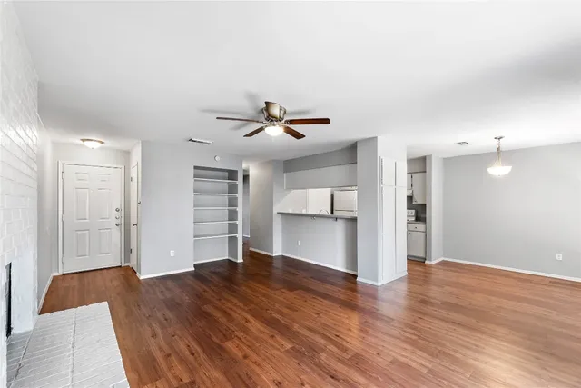 a view of empty room with wooden floor and window