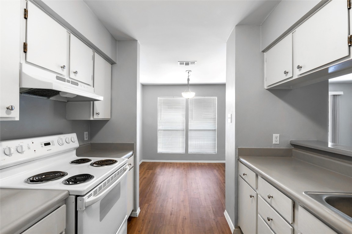 4304 Acropolis Court, Unit B Austin, TX 78759 - Photo 7 of 22 a kitchen with granite countertop a stove and a white wooden cabinets