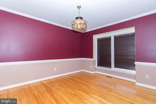 a view of a big room with wooden floor and windows