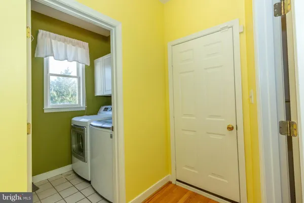 an empty room with a chandelier fan and windows