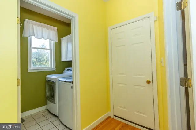 an empty room with a chandelier fan and windows