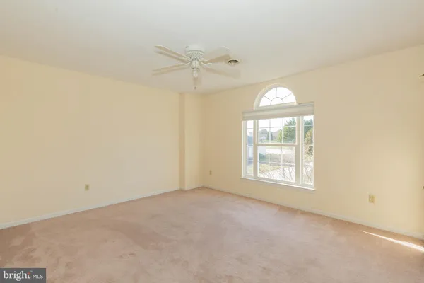 an empty room with closet and a chandelier fan