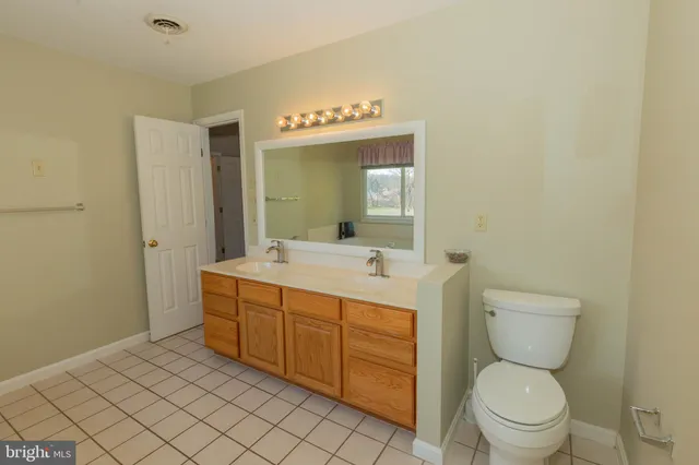 an empty room with windows and ceiling fan