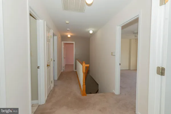 an empty room with a fan & a window