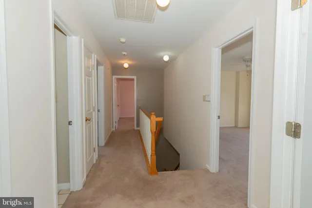 an empty room with a fan & a window