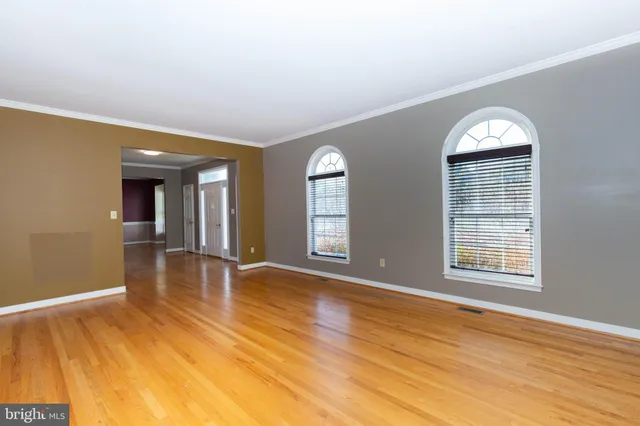 a view of empty room with wooden floor and ceiling fan