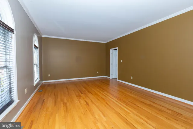 a view of empty room with wooden floor and fireplace
