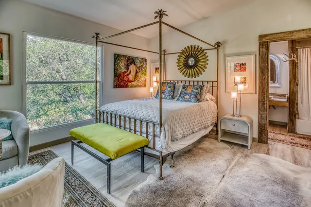 a bedroom with a bed a couch and a window