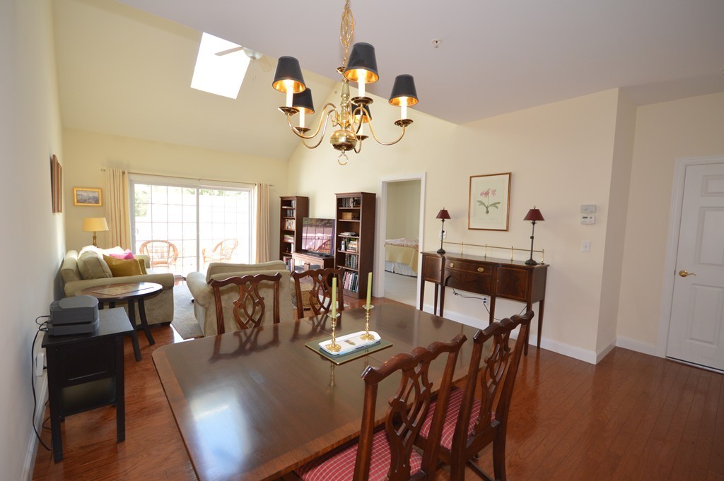704 Autumn Ridge Drive, Unit 704 Ayer, MA 01432 - Photo 11 of 30 a view of a dining room with furniture a chandelier and wooden floor