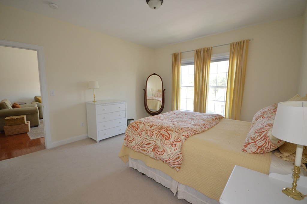 704 Autumn Ridge Drive, Unit 704 Ayer, MA 01432 - Photo 16 of 30 a bed sitting in a bedroom next to a window