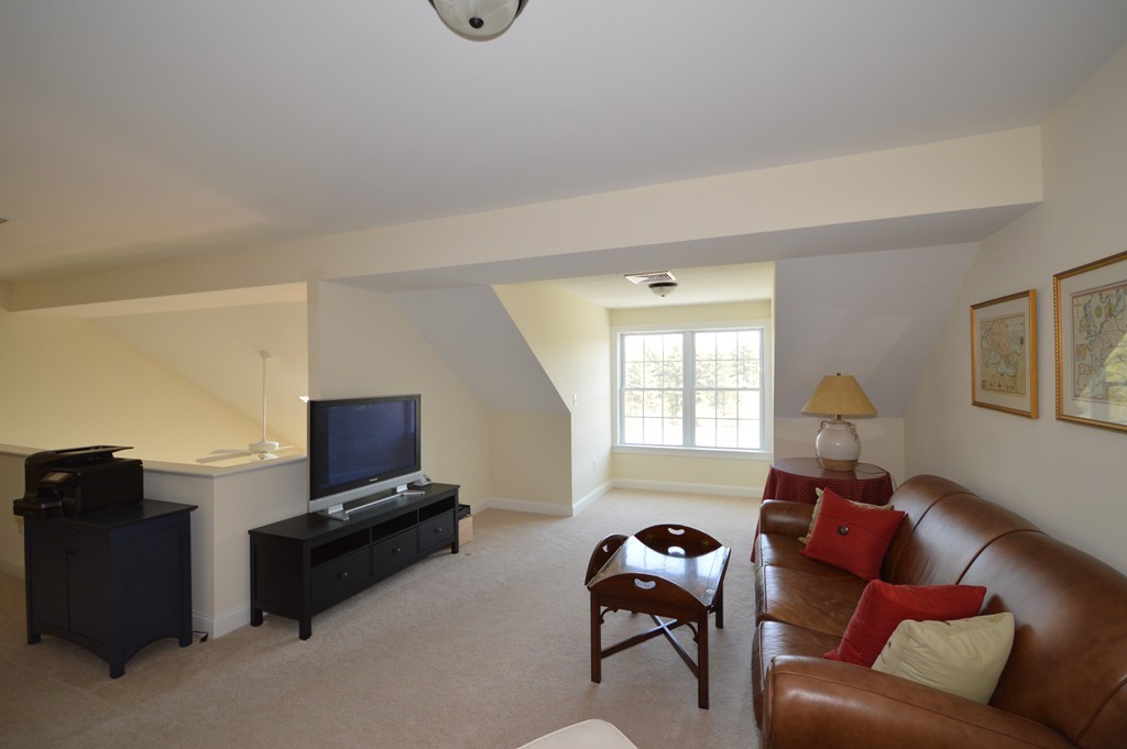 704 Autumn Ridge Drive, Unit 704 Ayer, MA 01432 - Photo 17 of 30 a living room with furniture and a flat screen tv