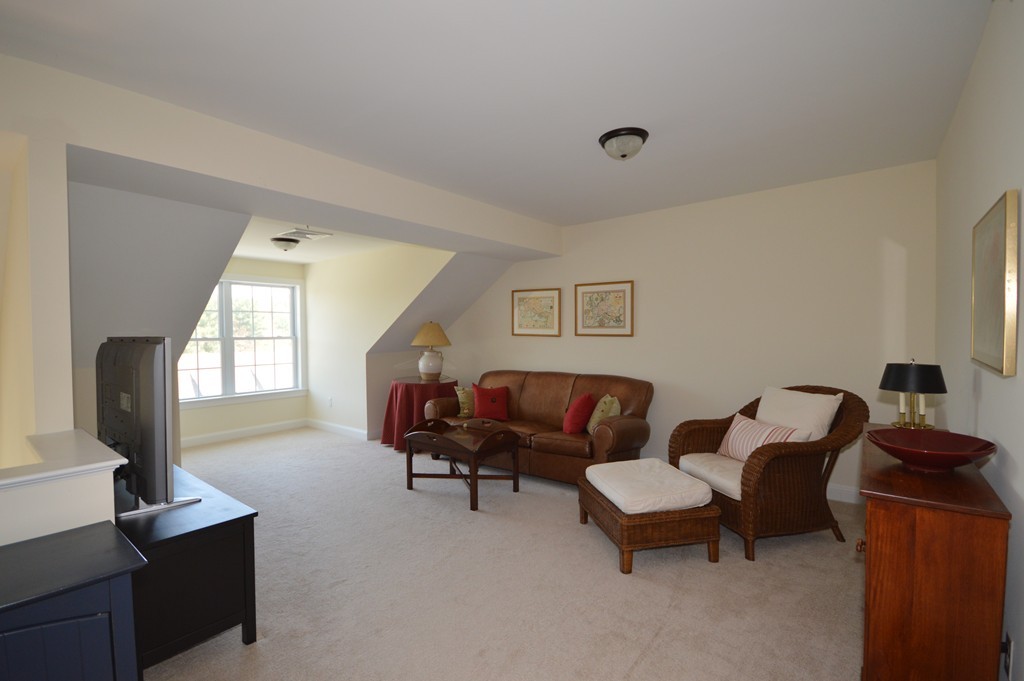704 Autumn Ridge Drive, Unit 704 Ayer, MA 01432 - Photo 18 of 30 a living room with furniture and a window