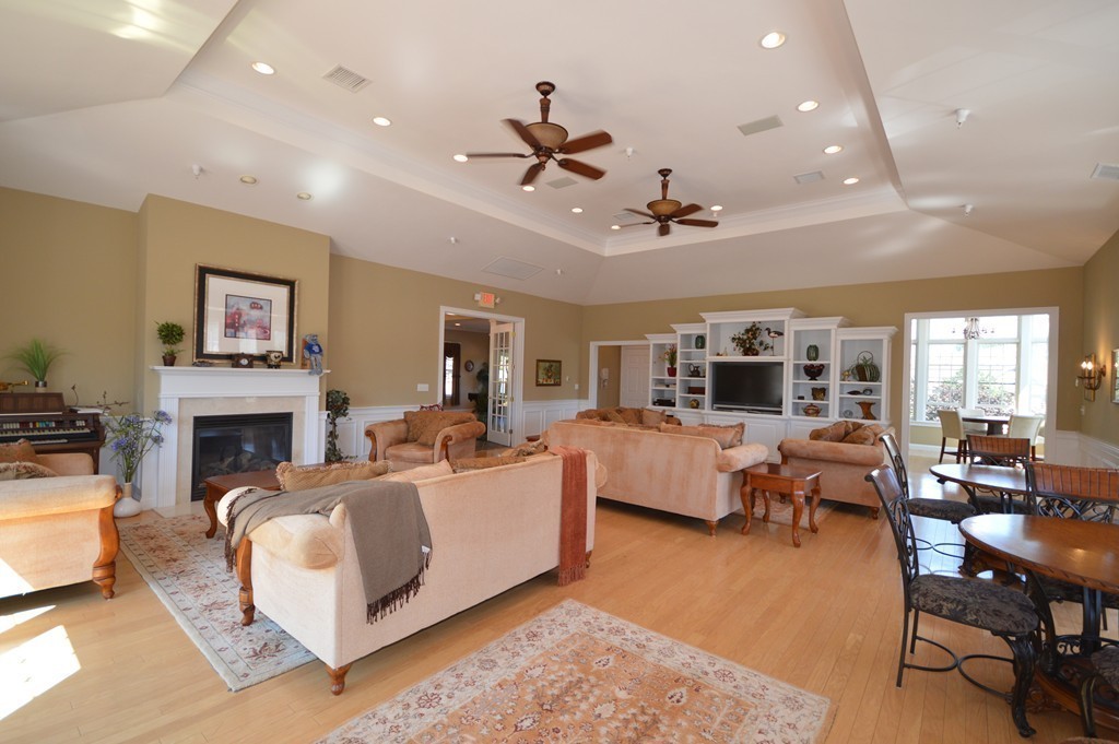 704 Autumn Ridge Drive, Unit 704 Ayer, MA 01432 - Photo 27 of 30 a living room with furniture fireplace and a flat screen tv