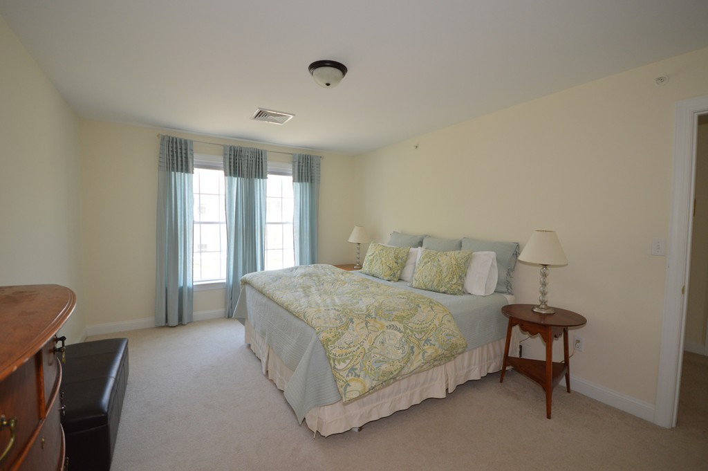 704 Autumn Ridge Drive, Unit 704 Ayer, MA 01432 - Photo 29 of 30 a spacious bedroom with a bed and a window