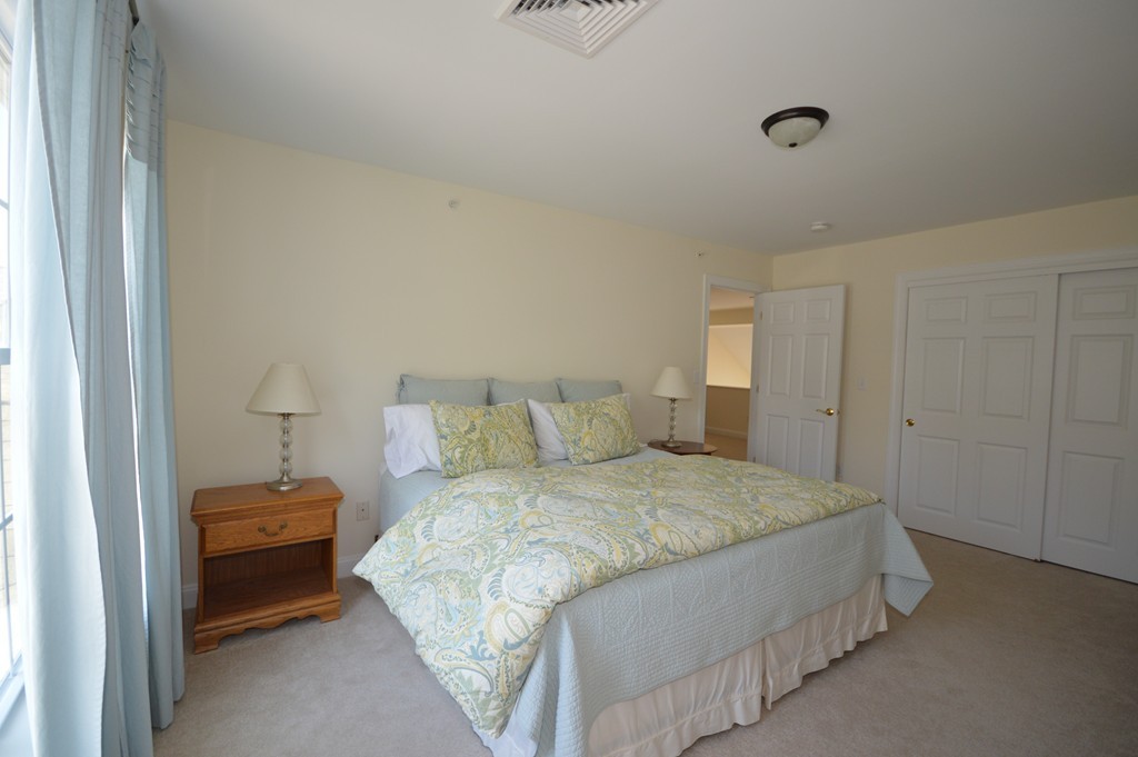 704 Autumn Ridge Drive, Unit 704 Ayer, MA 01432 - Photo 30 of 30 a bedroom with a bed and a lamp