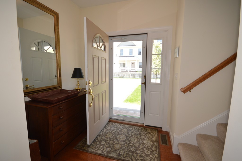 704 Autumn Ridge Drive, Unit 704 Ayer, MA 01432 - Photo 4 of 30 a view of a hallway with wooden floor and windows