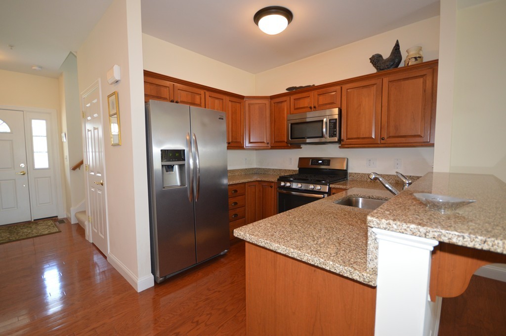 704 Autumn Ridge Drive, Unit 704 Ayer, MA 01432 - Photo 6 of 30 a kitchen with stainless steel appliances granite countertop a refrigerator a stove and a sink with granite countertops