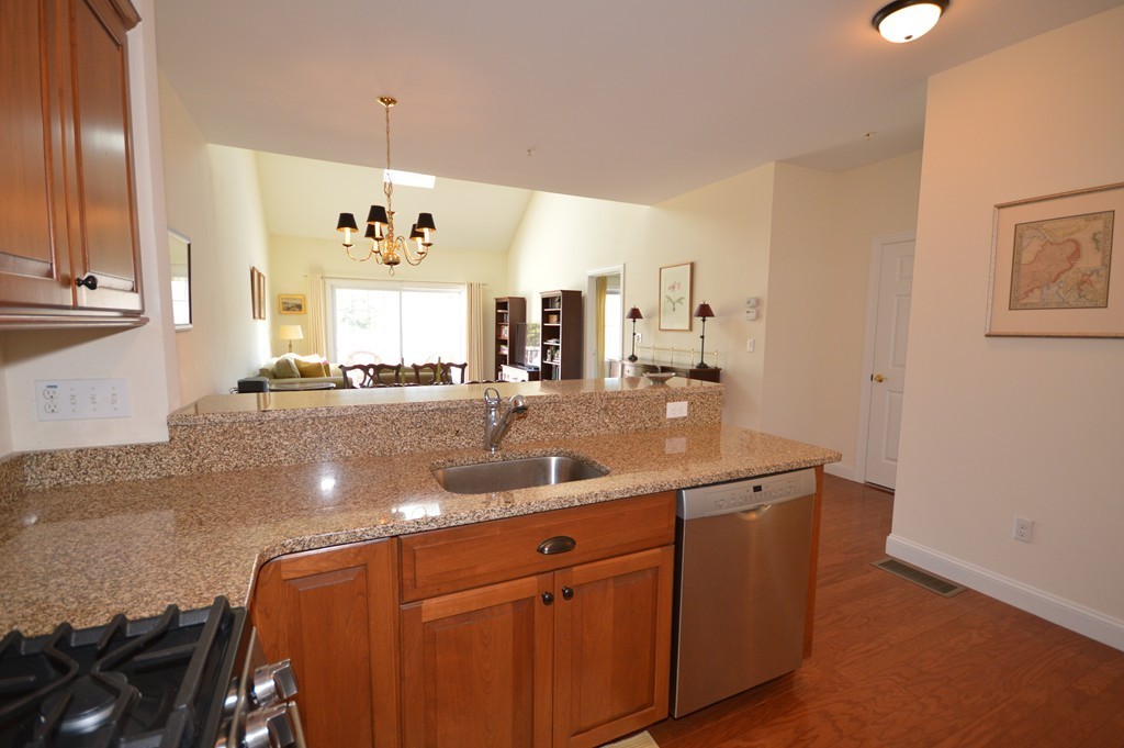 704 Autumn Ridge Drive, Unit 704 Ayer, MA 01432 - Photo 7 of 30 a kitchen with stainless steel appliances granite countertop a sink and a refrigerator