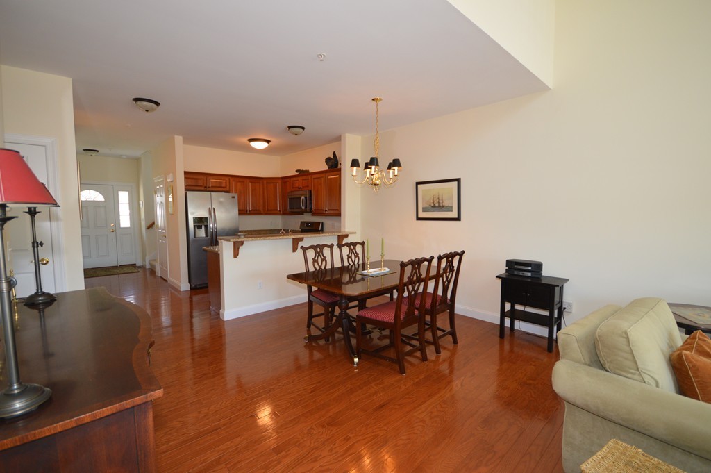 704 Autumn Ridge Drive, Unit 704 Ayer, MA 01432 - Photo 9 of 30 a view of a dining room with furniture and wooden floor