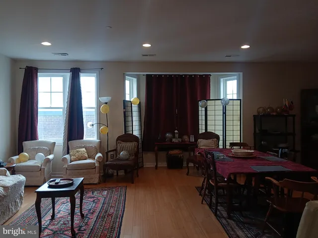 a living room with furniture a large window and wooden floor