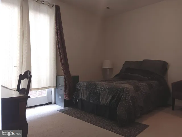 a bed sitting in a bedroom next to a window