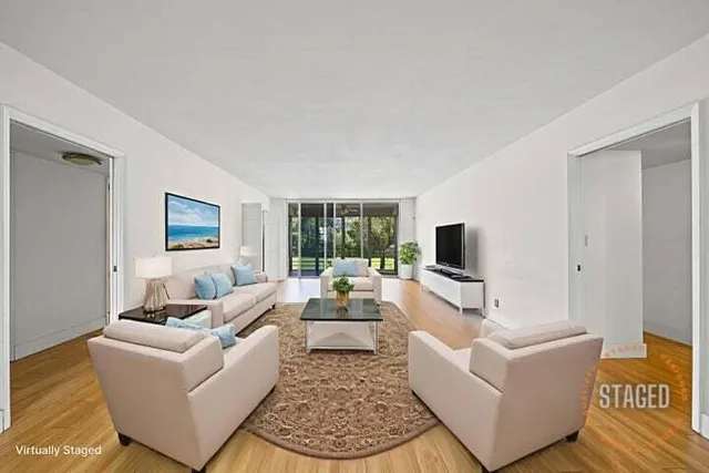a living room with furniture a flat screen tv and a large window
