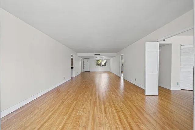 a view of empty room with wooden floor